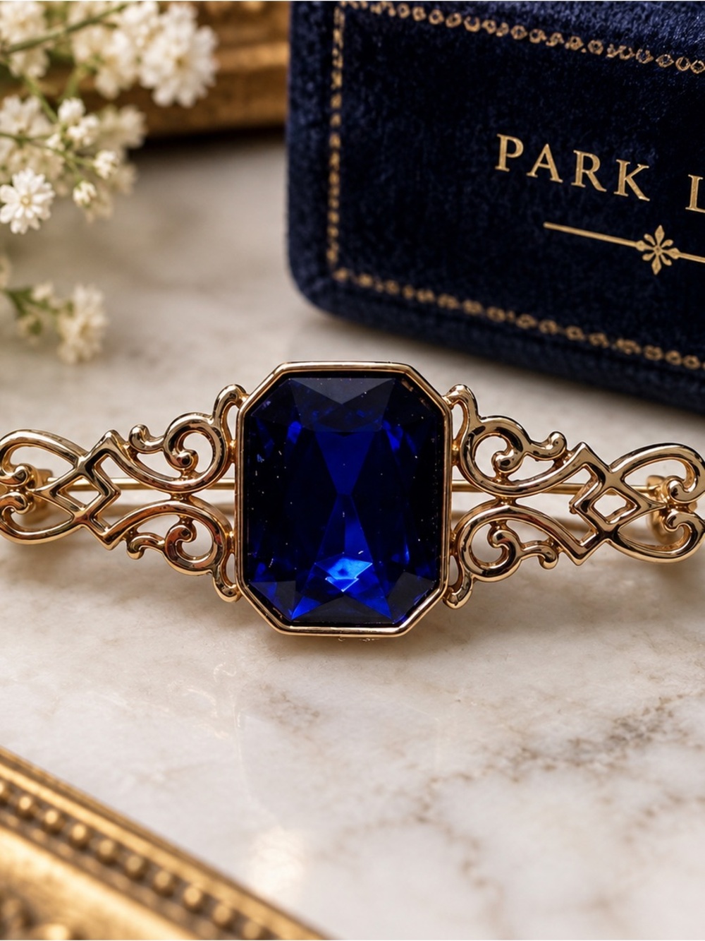 Park Lane Gold Brooch with Deep faceted Sapphire Blue Stone